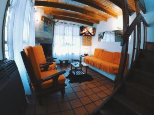 sala de estar con sofá naranja y mesa en Los Cerezos en San Martín de los Andes