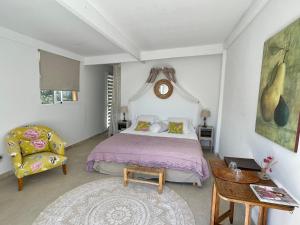 a bedroom with a bed and a table and a chair at B&B Villa Ganesh in Le Rouret