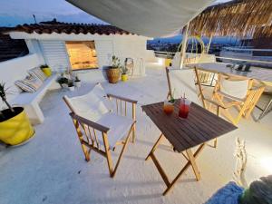 un patio con sillas, una mesa y una mesa con sillas en Alfa Loft (by Lemon Tree Houses), en Vrachati