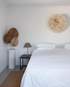 um quarto com uma cama e uma mesa com um candeeiro em MooiBaai em Hout Bay