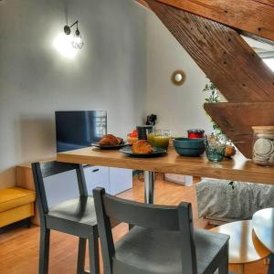 eine Küche mit einem Tisch mit Tellern voller Essen darauf in der Unterkunft Cœur de ville avec parking+gare à proximité de Disney et Paris in Lagny