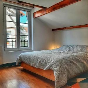 a bedroom with a bed and a large window at Cœur de ville avec parking+gare à proximité de Disney et Paris in Lagny