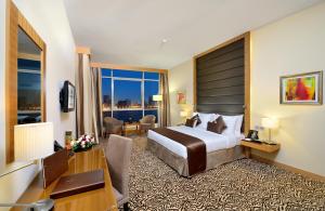 a hotel room with a bed and a desk at Copthorne Hotel Sharjah in Sharjah