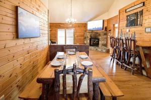 a dining room with a long wooden table and chairs at Four Private Suites - Hot Tub - Arcade - Fast Wi-Fi - One Minute To Parkway Fun in Pigeon Forge