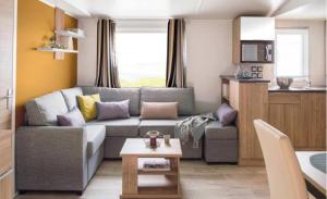 pequeña sala de estar con sofá y cocina en DOMAINE DE KERLANN-MH6PERS-2CH-grande terrasse-tout confort en Pont-Aven