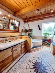 a bathroom with a tub and a sink at Wood & Stone Lodge 1 in Donaueschingen +11 photos