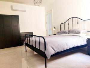 a bedroom with a large bed with a metal frame at BRAND NEW holiday accommodation in Xewkija