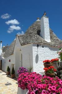 a white building with flowers in front of it at Romantic Trulli in Alberobello