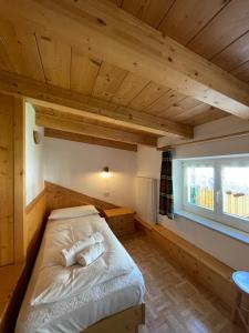 a large bed in a room with a window at Casa Cesarina by AMA Val di Fassa in Canazei