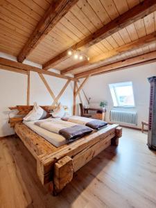 Habitación grande con cama grande de madera y techo de madera. en Wood & Stone Lodge 1, en Donaueschingen