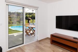 a living room with a sliding glass door leading to a patio at Refugio das Vinhas in Celorico de Basto