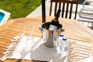 uma garrafa de vinho num balde numa mesa com copos em Refugio das Vinhas em Celorico de Basto