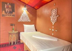 Dormitorio pequeño con cama y lámpara en Billion Stars Desert Camp, en Mhamid