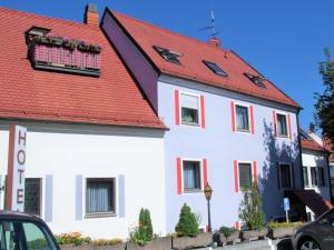 ein weißes Haus mit rotem Dach in der Unterkunft Hotel Brehm in Würzburg