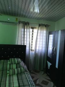 a bedroom with a bed and two windows at Holly House in Oshien