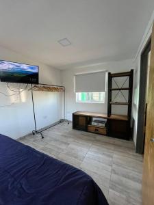 - une chambre avec un lit et une télévision à écran plat dans l'établissement Casa Quinta La Tranquera, à La Reja