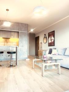 un soggiorno con un tavolo e un divano di DowntownApartments Carrie a Rzeszów