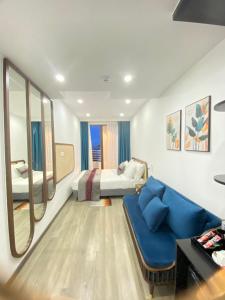 ダナンにあるGOODTECH LUXURY Hotel & Apartmentのリビングルーム(青いソファ、ベッド付)