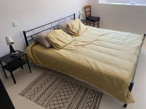 1 dormitorio con 1 cama grande con sábanas y almohadas amarillas en Gîte de cantaloup jumelé tout confort, climatisé, en Estadens
