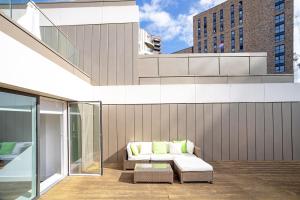 a patio with a couch on the side of a building at Modern, Stylish, Canalside PENTHOUSE Apartment Next to Wembley Stadium! in London