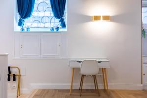 a white kitchen with a desk and a chair at RomeInSuite in Rome