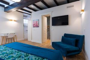 a bedroom with a blue bed and a chair at RomeInSuite in Rome