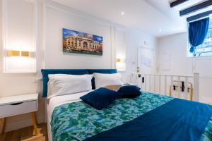a bedroom with a blue and white bed with blue pillows at RomeInSuite in Rome