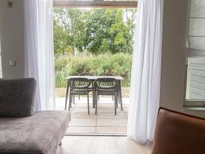 uma mesa e cadeiras numa sala de estar com uma janela em Nice holiday home near the waterfront with 2 bathrooms em Simonshaven