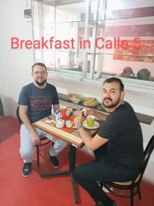 dos hombres sentados en una mesa comiendo comida en un restaurante en CALLE 5 - Lima AIRPORT, en Lima