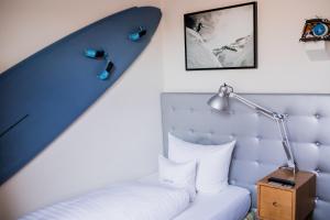 a bedroom with a bed with a surfboard on the wall at DORMERO Hotel Kehl in Kehl am Rhein +15 photos