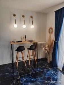 una habitación con un bar con dos taburetes en Studio avec jaccuzzi en Saintry-sur-Seine