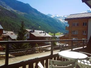 a balcony with a table and chairs and a mountain at Self service Guesthouse Berggeist in Saas-Fee