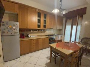 una cucina con tavolo e frigorifero di ST APARTMENT - DI FRONTE AL TRIBUNALE di Nocera a Nocera Inferiore