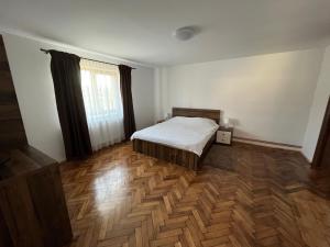 sypialnia z łóżkiem i drewnianą podłogą w obiekcie Casa Cheilor w mieście Petreştii de Jos