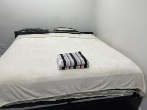 a white bed with a striped pillow on it at The Home Sweet Home in Winnipeg