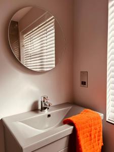 a bathroom with a white sink and a mirror at Modern Apartment Central Woodstock with Parking in Woodstock