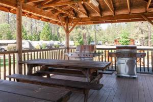 una mesa de picnic y una parrilla en la cubierta en The Lodge, 