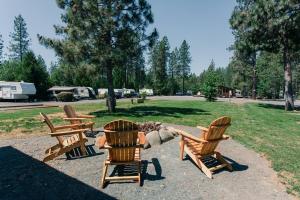 3 sillas de madera y una hoguera en un parque en The Lodge, 