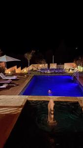 a person in a swimming pool at night at Riad Timskrine in Marrakech
