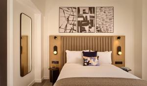 um quarto com uma cama com uma grande colcha branca em Citadines Holborn - Covent Garden London em Londres