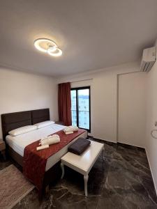 a bedroom with a bed and a table and a window at Alma's appartament in Sarandë