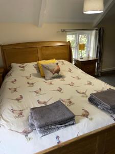 a bed with a blanket with birds on it at Charming cottage in Lyng