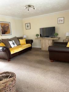 a living room with a couch and a flat screen tv at Charming cottage in Lyng