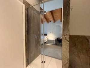 a glass shower in a bathroom with a bedroom at Agriturismo La Rondinella in Lazise