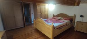 een slaapkamer met een houten bed en een houten vloer bij A&J House in Canale San Bovo