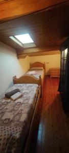 twee bedden in een kleine kamer met een raam bij A&J House in Canale San Bovo