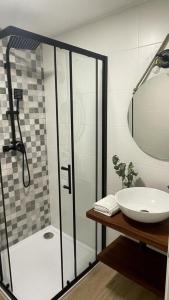 a bathroom with a shower and a sink and a mirror at A Marisma Hostal in Redondela