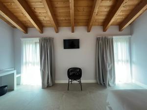 sypialnia z łóżkiem, krzesłem i oknami w obiekcie Agriturismo La Rondinella w mieście Lazise