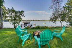 3 grüne Stühle auf dem Gras in der Nähe eines Sees in der Unterkunft Backus Lakefront Cabin with Fire Pit, Dock Access! 