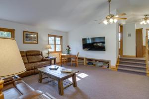 ein Wohnzimmer mit einem Sofa und einem Tisch in der Unterkunft Backus Lakefront Cabin with Fire Pit, Dock Access! 